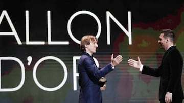 Real Madrid's Luke Modric hands the Ballon d'Or trophy with 2019 winner Lionel Messi.