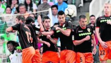 <b>MURALLA CHE. </b>Tchité (agachado), Joaquín, Banega, Villa, Navarro, Marchena y Mathieu saltan tras una falta sacada por el Racing.