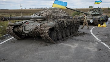 A Ukrainian serviceman walks near captured Russian tanks with installed Ukrainian flags, as Russia's attack on Ukraine continues, near the town of Izium, recently liberated by Ukrainian Armed Forces, in Kharkiv region, Ukraine September 19, 2022. REUTERS/Gleb Garanich