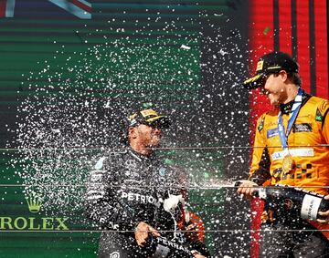 Oscar Piastri baña en champán a Lewis Hamilton en la celebración en el podio del GP de Hungría.