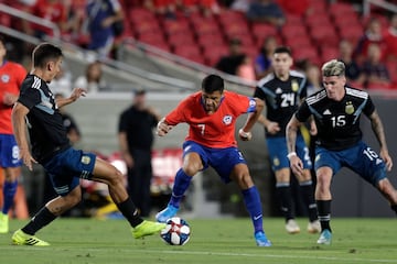 El jugador de la seleccion chilena Alexis Sanchez, centro, disputa el balón con la defensa de Argentina.