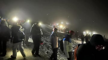 Turistas en el volcán Etna, cubierto de nieve, de noche