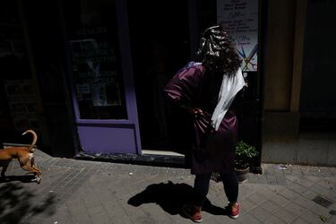 Una mujer que se estaba haciendo un tratamiento capilar espera fuera de la peluquería, que quedó a oscuras debido a un corte de luz en Madrid, España.