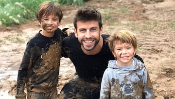 Gerard Piqu&eacute; con sus dos hijos, Milan y Sasha, muy sonrientes tras jugar en el barro.