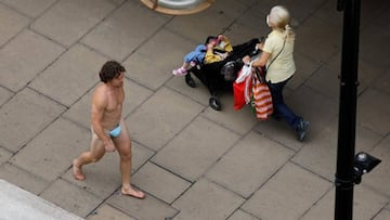 Un hombre pasea por el centro de Londres llevando solo una mascarilla