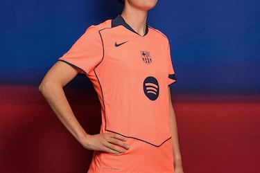 Un llamativo color mango brillante domina en la camiseta –también en los pantalones y las medias– acompañado de varios detalles en azul marino en forma de franjas en el cuello y en la espalda y de filetes que dibujan una forma geométrica en la parte frontal, con el logotipo de Spotify en el centro.