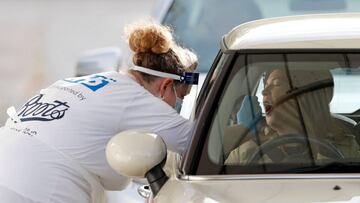 Drivers receive a novel coronavirus test at a drive-in COVID-19 testing facility set up at the Chessington World of Adventures Resort, in Chessington, southwest of London, on October 20, 2020. - British Prime Minister Boris Johnson, who was criticised for