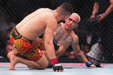 Ilia Topuria pelea en el suelo contra Charles Oliveira en la pelea por el título de campeón del peso ligero de la UFC.