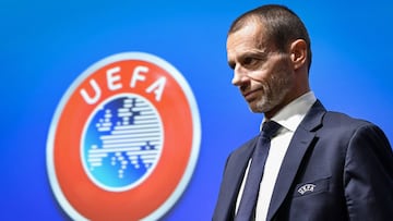 (FILES) In this file photo taken on December 4, 2019 UEFA President Aleksander Ceferin walks past a sign with the UEFA logo after attending a press conference following a meeting of the executive committee at the UEFA headquarters, in Nyon, Switzerland. -