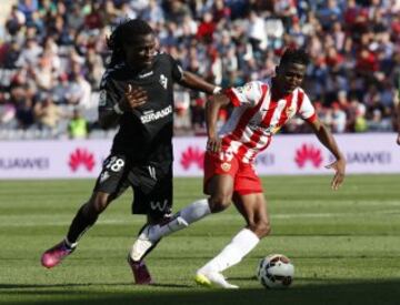 El delantero del Almería Jonathan Sundy Zongo con el balón seguido por el centrocampista del Eibar Derek Owusu Boateng