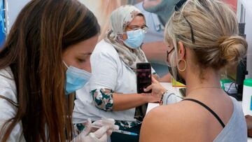 A Israeli healthcare worker vaccinates a woman against the COVID-19 coronavirus at Clalit Health Services, in the coastal city of Tel Aviv, on January 3, 2021. - Israel said two million people will have received a two-dose COVID-19 vaccination by the end of January, since the start on December 19, of an aggressive push to administer the vaccine made by US-German pharma alliance Pfizer-BioNTech. (Photo by JACK GUEZ / AFP)