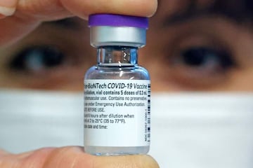 A medical worker displays a dose of COVID-19 vaccine.