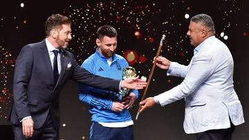 Argentina's forward Lionel Messi (C) receives a ceremonial baton of leadership from the president of Conmebol, Paraguayan Alejandro Dominguez (L), and the president of the Argentine Football Association (AFA), Claudio Tapia, during a tribute by Conmebol to the members of the Argentine national team for winning the Qatar 2022 World Cup, before the draw of the group phases of the Libertadores and Sudamericana football tournaments, at Conmebol's headquarters in Luque, Paraguay, on March 27, 2023. (Photo by NORBERTO DUARTE / AFP)
