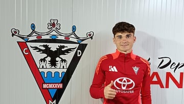 Joel Roca posa junto al escudo del Mirandés.