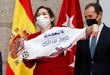 Isabel Díaz Ayuso recibe como obsequio una camiseta firmada por los miembros de la "Quinta del Buitre".
