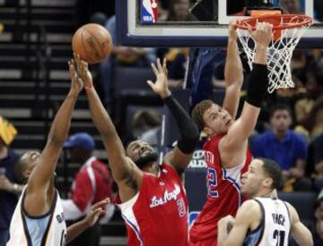 El jugador de los Angeles Clippers Ronny Turiaf lucha por el rebote mientras Blake Griffin se cuelga del aro.