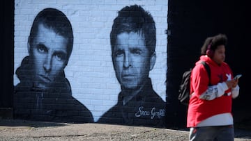 A man walks past a mural of Oasis band members Liam and Noel Gallagher by artist Snow Graffiti on the wall of the Coach and Horses pub in Whitefield, near Manchester, Britain, August 31, 2024. REUTERS/Phil Noble