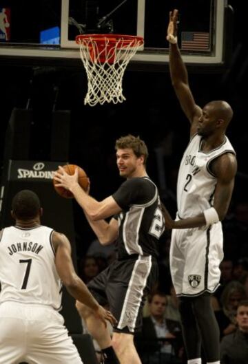 Tiago Splitter trata de encestar ante Kevin Garnett durante el Brooklyn-San Antonio.