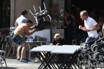 A Russian fan smashes a chair over an England supporter as another attacks him on the ground as they clash ahead of the game against Russia later today on June 11, 2016 in Marseille, France.