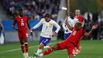 France's midfielder #07 Antoine Griezmann (C) and Canada's defender #13 Derek Cornelius (R) fight for the ball during the International friendly football match between France and Canada at the Matmut Atlantique stadium in Bordeaux, on June 9, 2024. (Photo by ROMAIN PERROCHEAU / AFP)