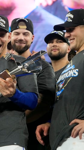 Oct 20, 2025; Toronto, Ontario, CAN; Toronto Blue Jays second baseman Andres Gimenez (0) celebrates with the trophy after defeating the in game seven of the ALCS round for the 2025 MLB playoffs at Rogers Centre. Mandatory Credit: John E. Sokolowski-Imagn Images
