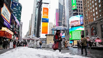 People make their way during a snowfall at Times Square in New York City, U.S., December 14, 2025. REUTERS/Eduardo Munoz