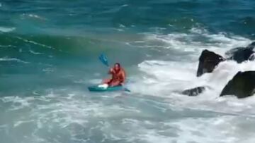 Kayakista a punto de ser enviado contra las rocas por una ola en Hawái.