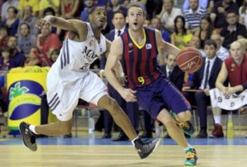 El base brasileño del FC Barcelona Marcelinho Huertas avanza ante la defensa del alero estadounidense del Real Madrid Tremmell Darden.