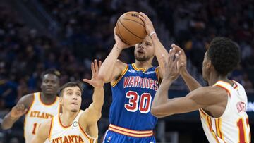 November 8, 2021; San Francisco, California, USA; Golden State Warriors guard Stephen Curry (30) shoots the basketball against Atlanta Hawks guard Bogdan Bogdanovic (13) and forward De'Andre Hunter (12) during the fourth quarter at Chase Center. Mandatory Credit: Kyle Terada-USA TODAY Sports