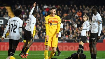 Barcelona's Polish forward #09 Robert Lewandowski (C) reacts as Valencia's Georgian goalkeeper #25 Giorgi Mamardashvili holds the ball during the Spanish league football match between Valencia CF and FC Barcelona at the Mestalla stadium in Valencia on December 16, 2023. (Photo by JOSE JORDAN / AFP)