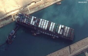 This satellite image released by Maxar Technologies shows tug boats and dredgers attempting to free the MV Ever Given on March 26, 2021, in the Suez Canal.