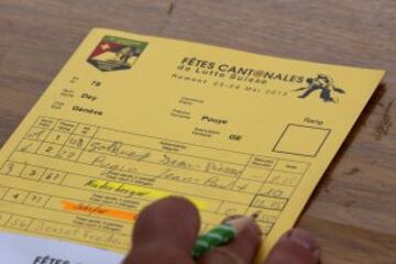 Un árbitro tiene la tarjeta del senegales luchador Dieylani Pouye durante una pelea en un torneo de clasificación en Romont. Pouye intentará clasificarse para el evento de lucha libre de Swiss Alpine Festival Federal de este año, el deporte más antiguo de Suiza