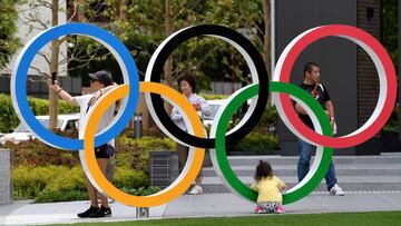 Varios japoneses posan con los aros ol&iacute;mpicos de Tokyo 2020.