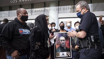 LAPD Chief of Police Michel Moore (R) is welcomed by community and religious leaders during a ceremony at the Los Angeles Police Department Headquarters. 