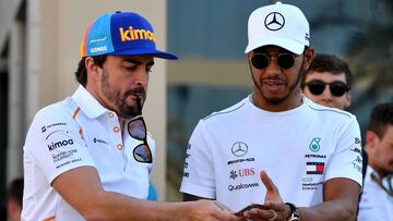 Mercedes' British driver Lewis Hamilton (R) walks down the paddock with McLaren's Spanish driver Fernando Alonso (L) ahead of the Abu Dhabi Formula One Grand Prix at the Yas Marina circuit on November 22, 2018. (Photo by Andrej ISAKOVIC / AFP)
