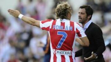 <b>DISPUTA. </b>Forlán y Quique discuten en el Vicente Calderón.