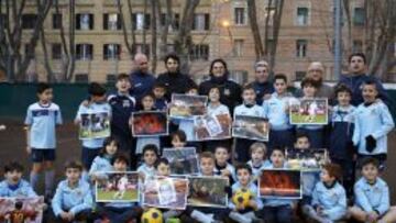 Todos quieren ser Totti. Los más pequeños del primer club de Totti posan con fotografías del crack, que se forjó en este campo de tierra.