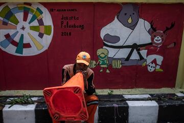 Un trabajador indonesio utiliza el cono de tráfico para animar a su equipo durante el partido.