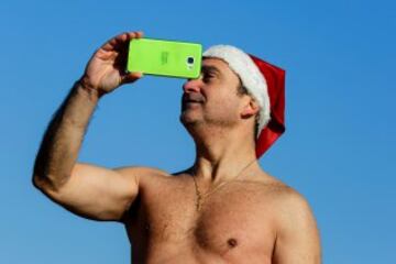 Decenas de ciudadanos participaron este mediodía en el tradicional primer baño del año en la playa de Sant Sebastià del barcelonés barrio de la Barceloneta.