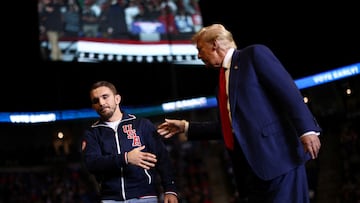 Republican presidential nominee and former U.S. President Donald Trump shakes hands with a member of the wrestling team of Penn State University during a rally in State College, Pennsylvania, U.S. October 26, 2024. REUTERS/Carlos Barria
