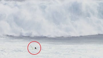 Un surfista rodeado por un c&iacute;rculo rojo ante la espuma de una ola gigante que ya ha roto y que le viene de frente en Uluwatu (Bali, Indonesia), en 2022. 