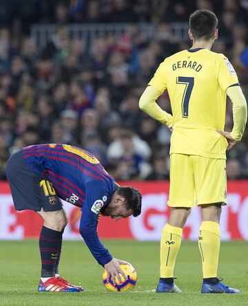 El futbolista del Barcelona Leo Messi se prepara para lanzar una falta ante la mirada del jugador del Villarreal Gerard. 