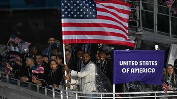 US' flag bearer LeBron James stands with other members of his delegation in a boat sailing along the Seine river during the opening ceremony of the Paris 2024 Olympic Games in Paris on July 26, 2024. (Photo by Mauro PIMENTEL / AFP)