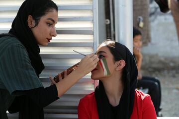 Seguidoras iraníes se pintan la cara con los colores de Irán en los alrededores del Estadio Azazi en Teherán para ver desde dentro del estadio el partido entre Irán y Camboya de fase de clasificación para el Mundial de 2022.