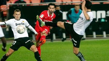 GRAFCVA638. VALENCIA, 22/12/2020.-.El jugador del Sevilla FC, Suso, dispara a puerta ante la oposición del Cheryshev (i) y Guedes (d) del Valencia CF durante el encuentro entre ambos equipos jugado en el estadio de Mestalla (Valencia). EFE/Kai F&ou