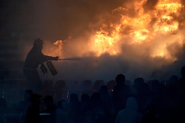 Un bombero extingue asientos en llamas durante un derbi de la liga nacional de fútbol de Serbia entre el Estrella Roja y el Partizán.