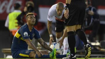 Referee Nestor Pitana (R) shows the red card to Boca Juniors' Colombian midfielder Edwin Cardona (L) during the Argentine derby match against River Plate in the Superliga first division tournament at Monumental stadium in Buenos Aires, Argentina, on November 5, 2017. / AFP PHOTO / JUAN MABROMATA