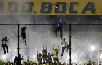 Fans of Boca Juniors climb a fence as they cheer for their team before the Copa Libertadores soccer match against River Plate in Buenos Aires, Argentina, May 14, 2015. REUTERS/Enrique Marcarian 