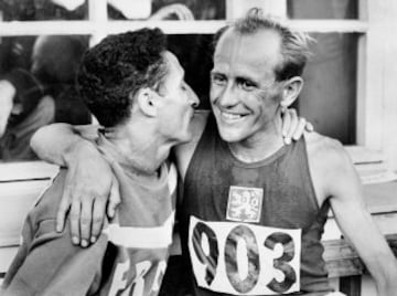 En los Juegos de Helsinki 1952 se superó a sí mismo. Primero ganó los 5.000. por apenas un segundo sobre Alain Mimoun y estableciendo un nuevo récord del mundo (14:06.6) en una de las conocidas como carrera del siglo. Instante de la carrera con Zatopek en primer lugar, Alain Mimoun segundo, y Herbert Schade tercero. Así sería el podio de la prueba. En la imagen recibe la felicitación del francés Mimoun, rivales y amigos.