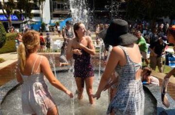 Aficionados al tenis refrescandose durante los descansos para hacer frente a las temperaturas que llegan a 43 grados centígrados (109 Fahrenheit) durante el cuarto dia del Abierto de Australia 2014 en Melbourne Park